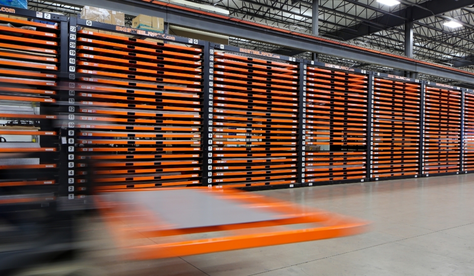 forklift moving sheet metal through warehouse
